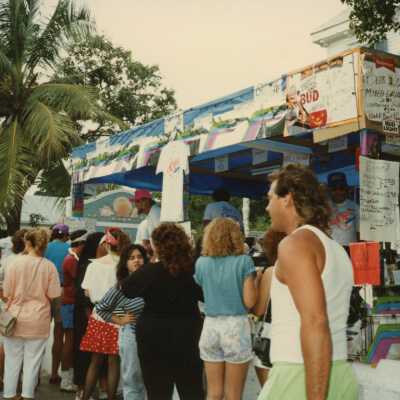 A group of unknown people standing near a booth.