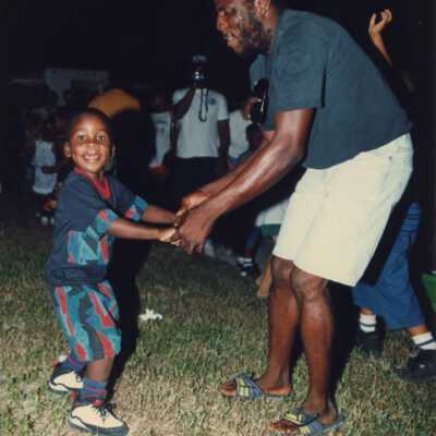 Unknown man and child dancing at the Goombay celebration.