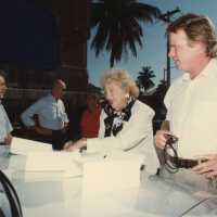 A group of unknown people standing outside of the Custom House with Wilhelmina Harvey.