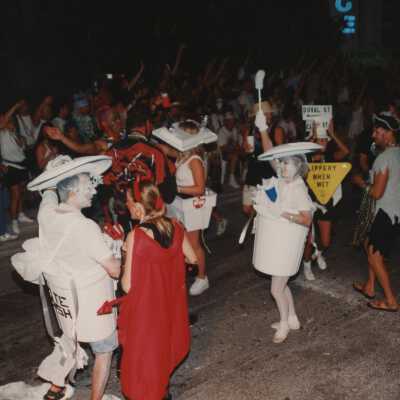 Unknown people dressed up walking in the street for the parade.