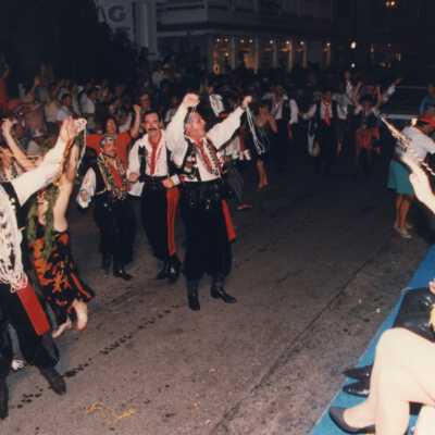 Unknown people walking down the street dressed up during the parade.
