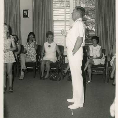 An unknown man talking to a group of people