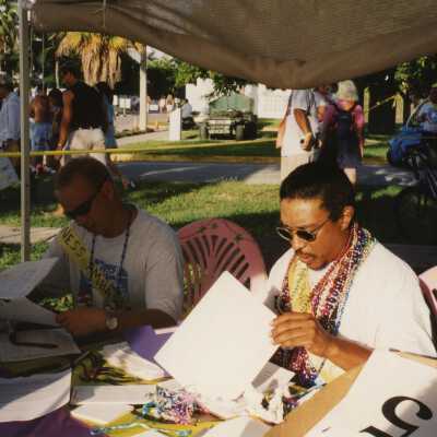 Two unknown men sitting at a table looking at paper work.