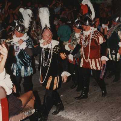 Unknown people dressed up walking in the street for the parade.