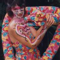 An unknown woman painted and dressed like a snake.