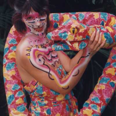 An unknown woman painted and dressed like a snake.