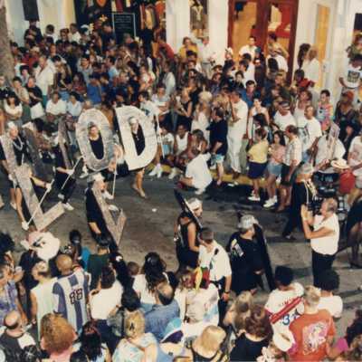 People walking in the parade dressed at the Hollywood letters.