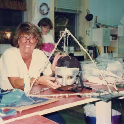 Unknown woman sitting at a table with a mask.