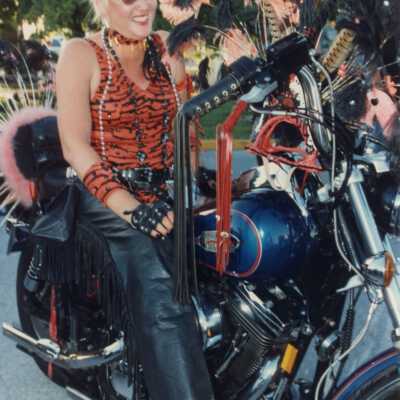 Unknown lady dressed up on a motorcycle.