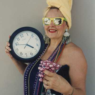 Unknown woman dressed up holding a clock.