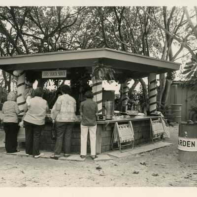 A group of people standing at a snack shack