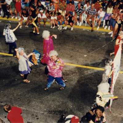 Unknown people dancing in the street in the parade.