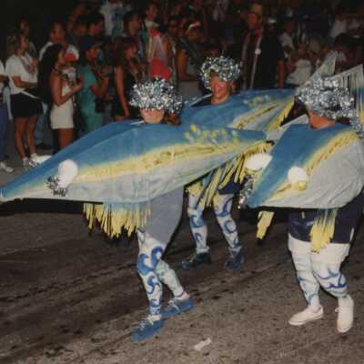 Unknown people dressed up walking in the street for the parade.