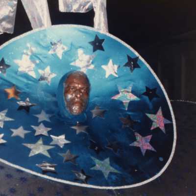 An unknown man dressed up walking in the parade.