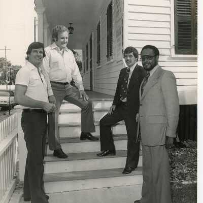 4 Unknown men standing on the stairway at a museum