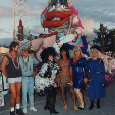 Unknown people dressed up standing near a float.