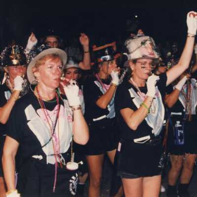 Unknown people dressed up blowing whistles in the parade.