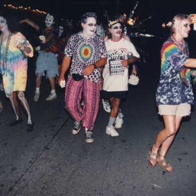 Unknown people dressed up walking in the street for the parade.