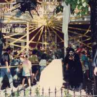 A group of unknown people standing in the front yard at the Woman