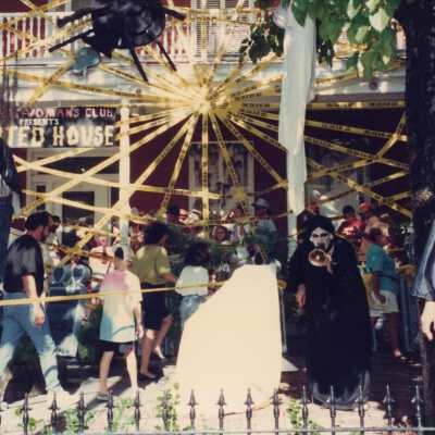 A group of unknown people standing in the front yard at the Woman's Club.