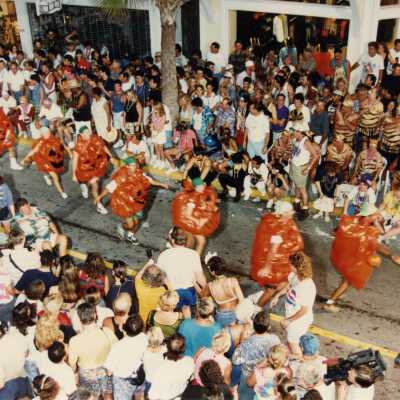 Unknown people dressed up and dancing on the street for the parade.
