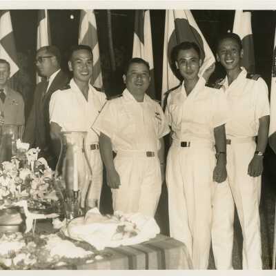 4 Unknown oriental men in uniform at a party.