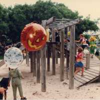 A playground with children that are dressed up playing.