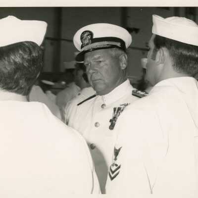 An unknown man in uniform standing with others around