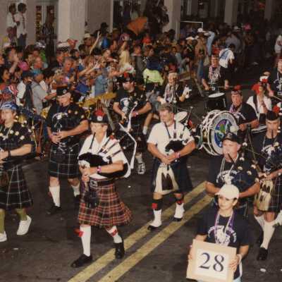 An unknown group of people playing in a band in the parade.