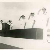 A group of men in uniform standing at attention near a podium