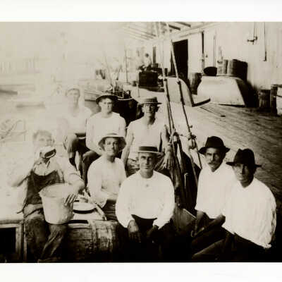 Unknown Men Sitting on a Wharf