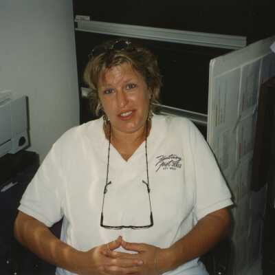 An unknown woman sitting at a desk.