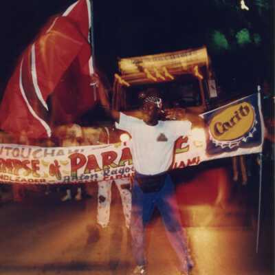 Unknown man in the parade holding a flag.