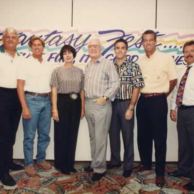Unknown people standing if front of the Fantasy Fest sign.