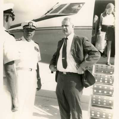 U.S. Navy men talking to unknown man in front of plane