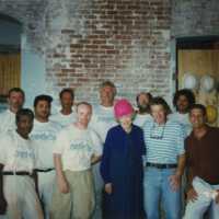 A group of unknown men standing with Wilhelmina Harvey inside of the Custom House.
