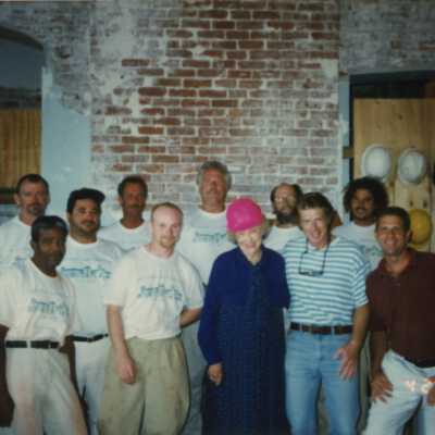 A group of unknown men standing with Wilhelmina Harvey inside of the Custom House.
