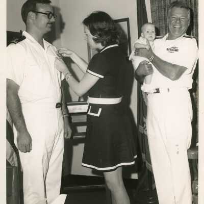 Unknown woman putting a pin on a U.S. Navy man