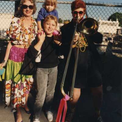 Unknown people standing dressed up in front of the cemetery.