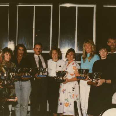 A group of unknown people holding trophy's.