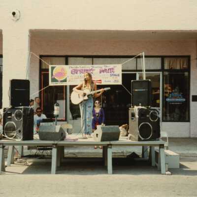 A stage in front of La Concha, with an unknown person singing.