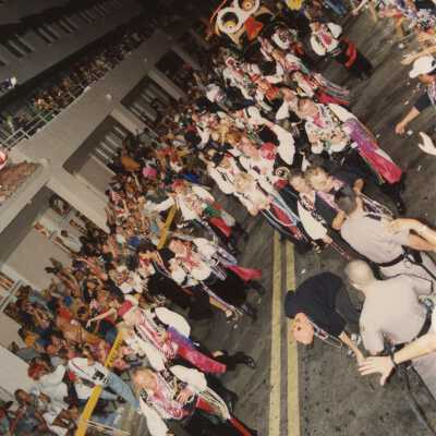 Unknown people dressed up walking in the street for the parade.