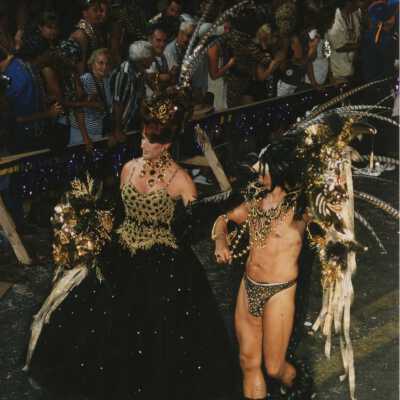 Two unknown people dressed up walking in the parade.
