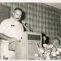 A man in uniform speaking at the podium