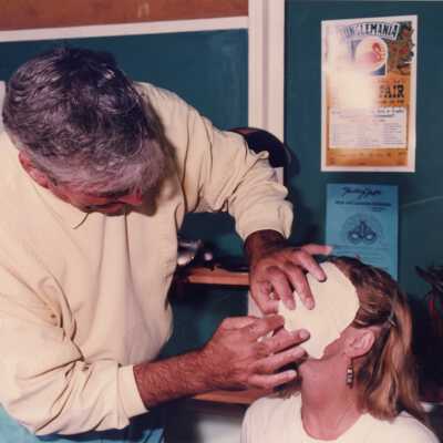 Unknown man putting a mask on a woman's face.
