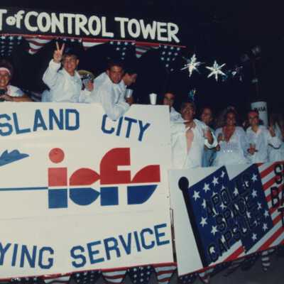 People dressed up on the Island City Flying service float.