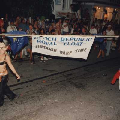 Two unknown people holding a banner that reads Conch Republic Royal float.