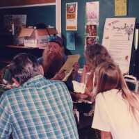 A group of unknown people sitting at a table talking.