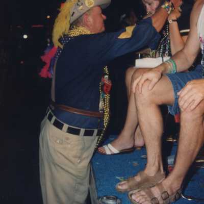 Unknown man dressed giving someone beads.