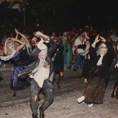 Unknown people dressed up walking in the street for the parade.